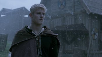 Movie still from “Vikings” (2013), created by Michael Hirst – A man in a hooded jacket standing in the snow; Close Up shot, Low angle