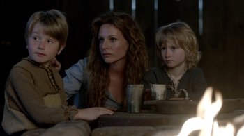 Movie still from “Vikings” (2013), created by Michael Hirst – A woman and two children sitting at a table; Medium shot, Over the shoulder angle