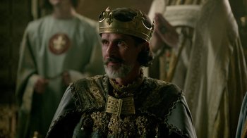Movie still from “Vikings” (2013), created by Michael Hirst – A man with a beard wearing a gold crown; Close Up shot, Over the shoulder angle