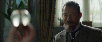 Movie still from “Colette” (2018), directed by Wash Westmoreland – A person wearing a suit and tie; Close Up shot, Over the shoulder angle