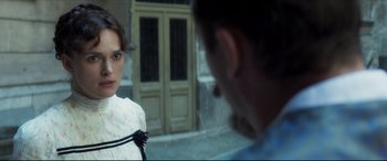 Movie still from “Colette” (2018), directed by Wash Westmoreland – A man and a woman standing next to each other on the street; Close Up shot, Over the shoulder angle