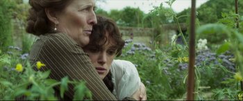 Movie still from “Colette” (2018), directed by Wash Westmoreland – A woman and a man are hugging in a field; Close Up shot, Low angle