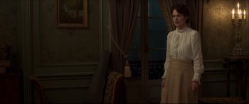 Movie still from “Colette” (2018), directed by Wash Westmoreland – A woman standing in front of an open door; Medium shot, Over the shoulder angle