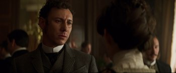 Movie still from “Colette” (2018), directed by Wash Westmoreland – A man wearing a suit and tie looking at a woman; Close Up shot, Over the shoulder angle