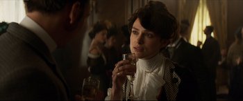 Movie still from “Colette” (2018), directed by Wash Westmoreland – A woman holding a wine glass in her hand; Close Up shot, Over the shoulder angle