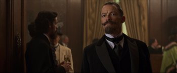 Movie still from “Colette” (2018), directed by Wash Westmoreland – A man in a suit and tie with a mustache; Close Up shot, Low angle