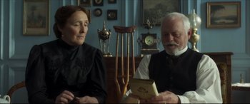 Movie still from “Colette” (2018), directed by Wash Westmoreland – A man and a woman sitting next to each other in a room; Medium shot, Over the shoulder angle