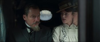 Movie still from “Colette” (2018), directed by Wash Westmoreland – A man and a woman sitting in the back of a car; Close Up shot, Over the shoulder angle