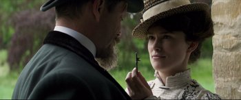 Movie still from “Colette” (2018), directed by Wash Westmoreland – A man and a woman holding a stick; Close Up shot, Over the shoulder angle