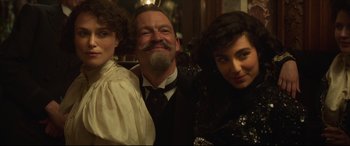Movie still from “Colette” (2018), directed by Wash Westmoreland – A man and two women posing for a picture; Close Up shot, Low angle