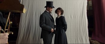 Movie still from “Colette” (2018), directed by Wash Westmoreland – A man and a woman dressed up in black; Medium shot, Low angle