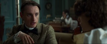 Movie still from “Colette” (2018), directed by Wash Westmoreland – A man sitting in front of another man in front of a table; Close Up shot, Over the shoulder angle