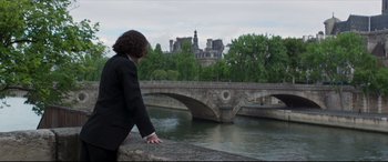 Movie still from “Colette” (2018), directed by Wash Westmoreland – A woman standing on a bridge over a river; Wide shot, High angle