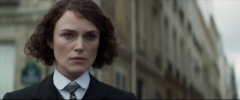 Movie still from “Colette” (2018), directed by Wash Westmoreland – A person wearing a suit and tie; Close Up shot, Over the shoulder angle