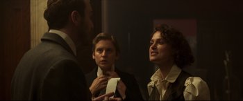 Movie still from “Colette” (2018), directed by Wash Westmoreland – A group of people standing next to each other in a room; Medium shot, Over the shoulder angle