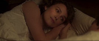 Movie still from “Colette” (2018), directed by Wash Westmoreland – A beautiful young lady laying in bed with her head resting on a pillow; Close Up shot, Overhead angle