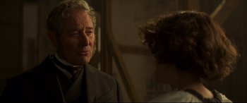Movie still from “Colette” (2018), directed by Wash Westmoreland – An older man wearing a suit and tie; Close Up shot, Over the shoulder angle