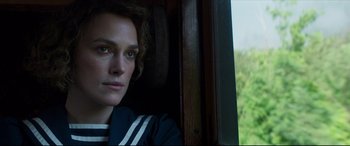 Movie still from “Colette” (2018), directed by Wash Westmoreland – A woman sitting on a train looking out the window; Close Up shot, Over the shoulder angle