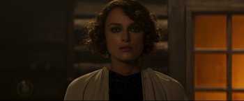 Movie still from “Colette” (2018), directed by Wash Westmoreland – A person with curly hair; Close Up shot, Over the shoulder angle