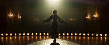 Movie still from “Colette” (2018), directed by Wash Westmoreland – A woman standing on a stage with her arms outstretched; Wide shot, Low angle