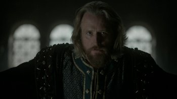 Movie still from “Vikings” (2013), created by Michael Hirst – A man with long hair and a beard wearing a suit; Close Up shot, Over the shoulder angle