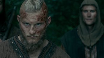 Movie still from “Vikings” (2013), created by Michael Hirst – A person with a beard and face paint; Close Up shot, Low angle
