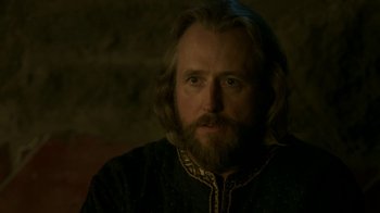 Movie still from “Vikings” (2013), created by Michael Hirst – A man with long hair and a beard wearing a black shirt; Close Up shot, Over the shoulder angle