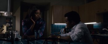Movie still from “Come Sunday” (2018), directed by Joshua Marston – A man and a woman sitting at a table talking; Medium shot, Over the shoulder angle