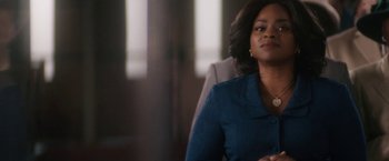 Movie still from “Come Sunday” (2018), directed by Joshua Marston – A woman sitting in front of a window; Close Up shot, Over the shoulder angle