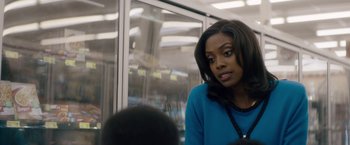 Movie still from “Come Sunday” (2018), directed by Joshua Marston – A woman sitting on a train looking at the camera; Close Up shot, Over the shoulder angle