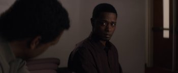 Movie still from “Come Sunday” (2018), directed by Joshua Marston – A man in a brown shirt is looking at a mirror; Close Up shot, Over the shoulder angle