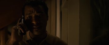 Movie still from “Come Sunday” (2018), directed by Joshua Marston – A person in a dark room; Close Up shot, Low angle