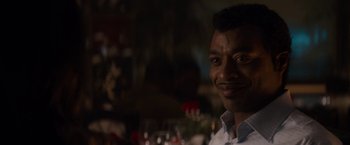 Movie still from “Come Sunday” (2018), directed by Joshua Marston – A person wearing a white dress shirt; Close Up shot, Over the shoulder angle