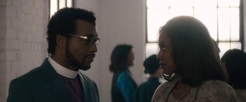 Movie still from “Come Sunday” (2018), directed by Joshua Marston – A man and a woman talking to each other; Close Up shot, Over the shoulder angle