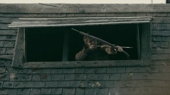 Movie still from “Vikings” (2013), created by Michael Hirst – A man holding a wooden stick in a window sill; Medium shot, Low angle