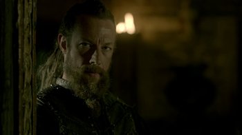 Movie still from “Vikings” (2013), created by Michael Hirst – A man with long hair and a long beard; Close Up shot, Over the shoulder angle