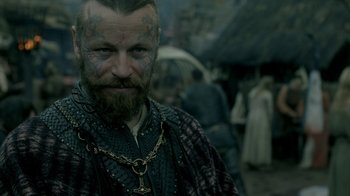 Movie still from “Vikings” (2013), created by Michael Hirst – A person with a tattoo on his face; Close Up shot, Over the shoulder angle