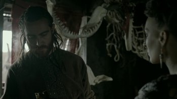 Movie still from “Vikings” (2013), created by Michael Hirst – A man with long hair and a beard looking at a cell phone; Medium shot, Low angle