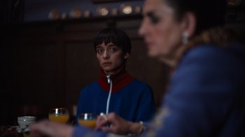 Movie still from “Copenhagen Cowboy” (2022), created by Nicolas Winding Refn – Two people sitting at a table with a drink in front of them; Close Up shot, Over the shoulder angle