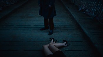 Movie still from “Copenhagen Cowboy” (2022), created by Nicolas Winding Refn – A woman lying on the ground next to a man in a black suit; Wide shot, High angle