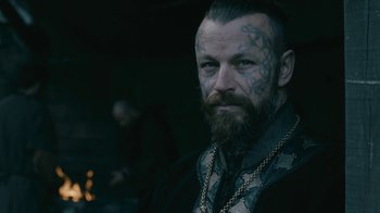 Movie still from “Vikings” (2013), created by Michael Hirst – A person with tattoos on their face; Close Up shot, Over the shoulder angle