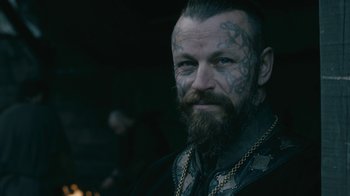 Movie still from “Vikings” (2013), created by Michael Hirst – A person with tattoos on their face; Close Up shot, Over the shoulder angle