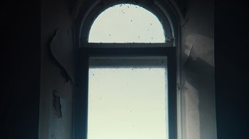 Movie still from “Copenhagen Cowboy” (2022), created by Nicolas Winding Refn – A view of the outside of a window; Extreme Close Up shot, Low angle