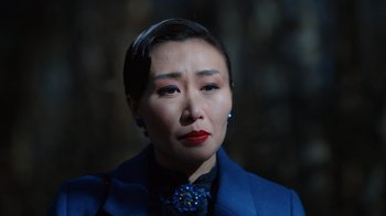 Movie still from “Copenhagen Cowboy” (2022), created by Nicolas Winding Refn – A person with short hair wearing a blue jacket; Close Up shot, Over the shoulder angle