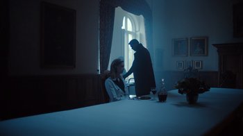 Movie still from “Copenhagen Cowboy” (2022), created by Nicolas Winding Refn – A man and a woman sitting at a dinner table; Medium shot, Low angle