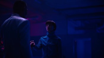 Movie still from “Copenhagen Cowboy” (2022), created by Nicolas Winding Refn – A man and a woman are standing in the dark; Medium shot, Over the shoulder angle