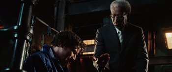 Movie still from “Wanted” (2008), directed by Timur Bekmambetov – A man in a suit and tie standing next to another man in a suit and tie; Medium shot, Over the shoulder angle