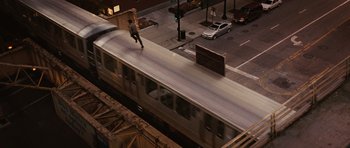 Movie still from “Wanted” (2008), directed by Timur Bekmambetov – A man riding a skateboard on the side of a train; Extreme Wide shot, High angle