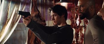 Movie still from “Wanted” (2008), directed by Timur Bekmambetov – A man holding a knife in his hand in front of a bunch of meat; Medium shot, Low angle