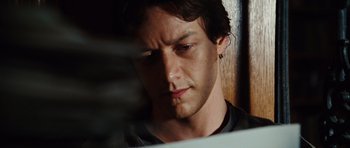 Movie still from “Wanted” (2008), directed by Timur Bekmambetov – A person looking down at a computer screen; Close Up shot, Low angle